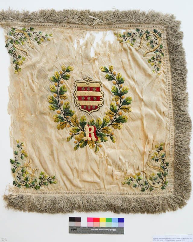 Zerknittertes, eingerissenes Seidenfahnenblatt mit gesticktem Wappen und Eichenlaubkranz.