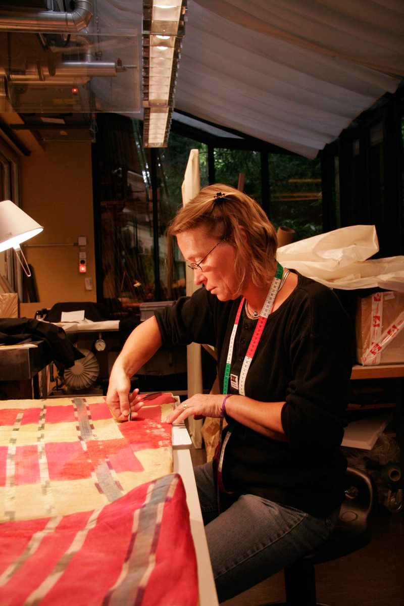 Ina von Woyski arbeitet im Atelier an einem grossflächig ausgelegten historischen Gewebe.